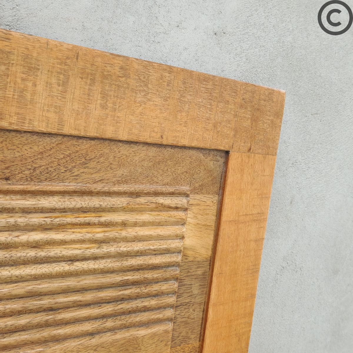 Zoom sur la texture du bois et les rainures d’une tête de lit en manguier massif – Mobilier artisanal KUKUU