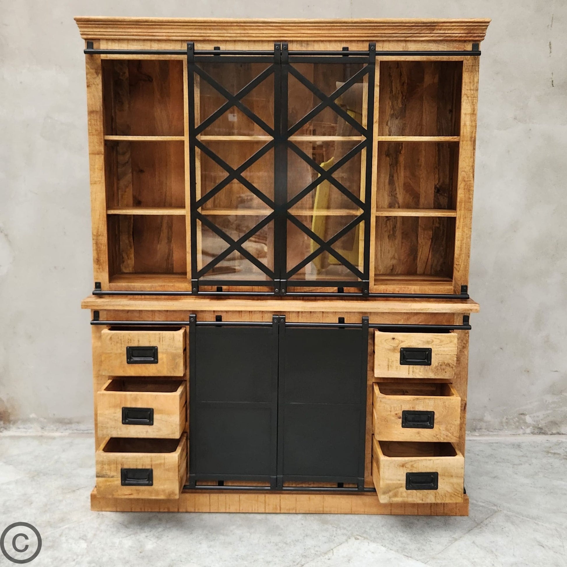 Ce vaisselier industriel a été fabriqué à partir de bois massif de manguier pour sa structure et d'acier et verre pour ses portes coulissantes. Kukuu, meubles industriels de qualité.