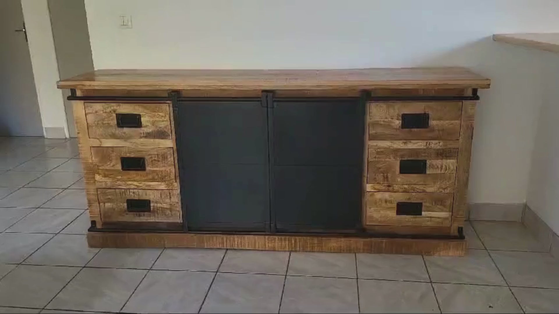 Buffet industriel, fait en bois massif de manguier et métal. Cette enfilade est composée de 6 tiroirs en bois, 2 portes coulissantes et de 2 étagères . Le mélange bois brut et métal apportera une touche unique et pleine de charme à votre intérieur. Disponible en 160 et 200 cm. Kukuu, meubles industriels de qualité.