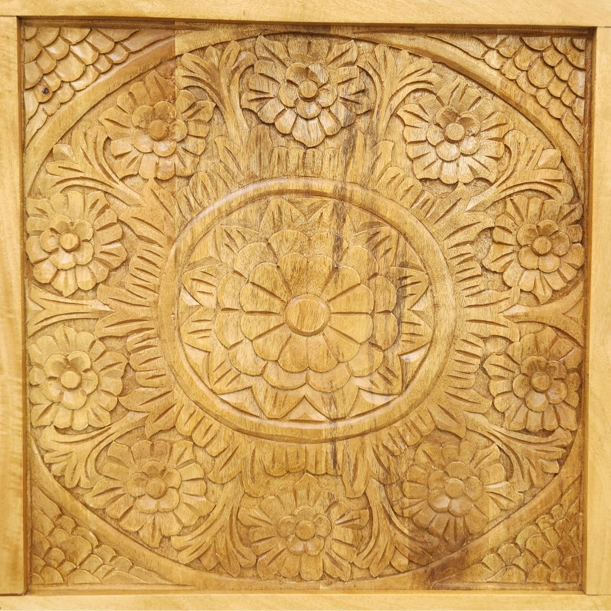 Gros plan sur la sculpture florale d’une tête de lit KUKUU en bois de manguier massif, travaillée à la main.