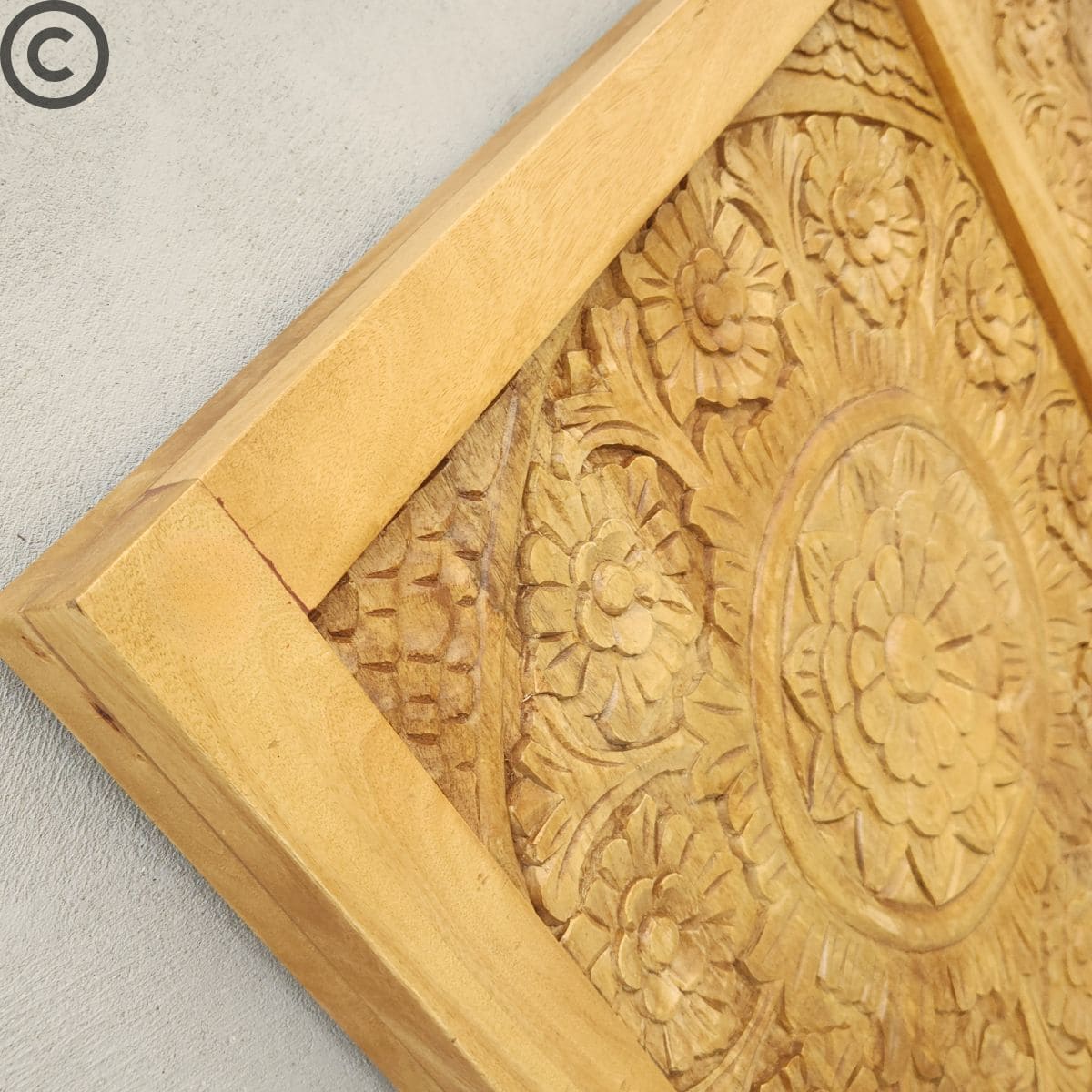 Détail de la finition artisanale du cadre en bois massif d’une tête de lit sculptée KUKUU.