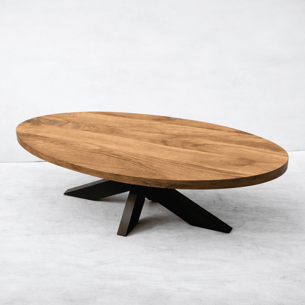vue de côté d'une table basse ovale industrielle KUKUU faite en bois massif de manguier et pieds mikado en métal.