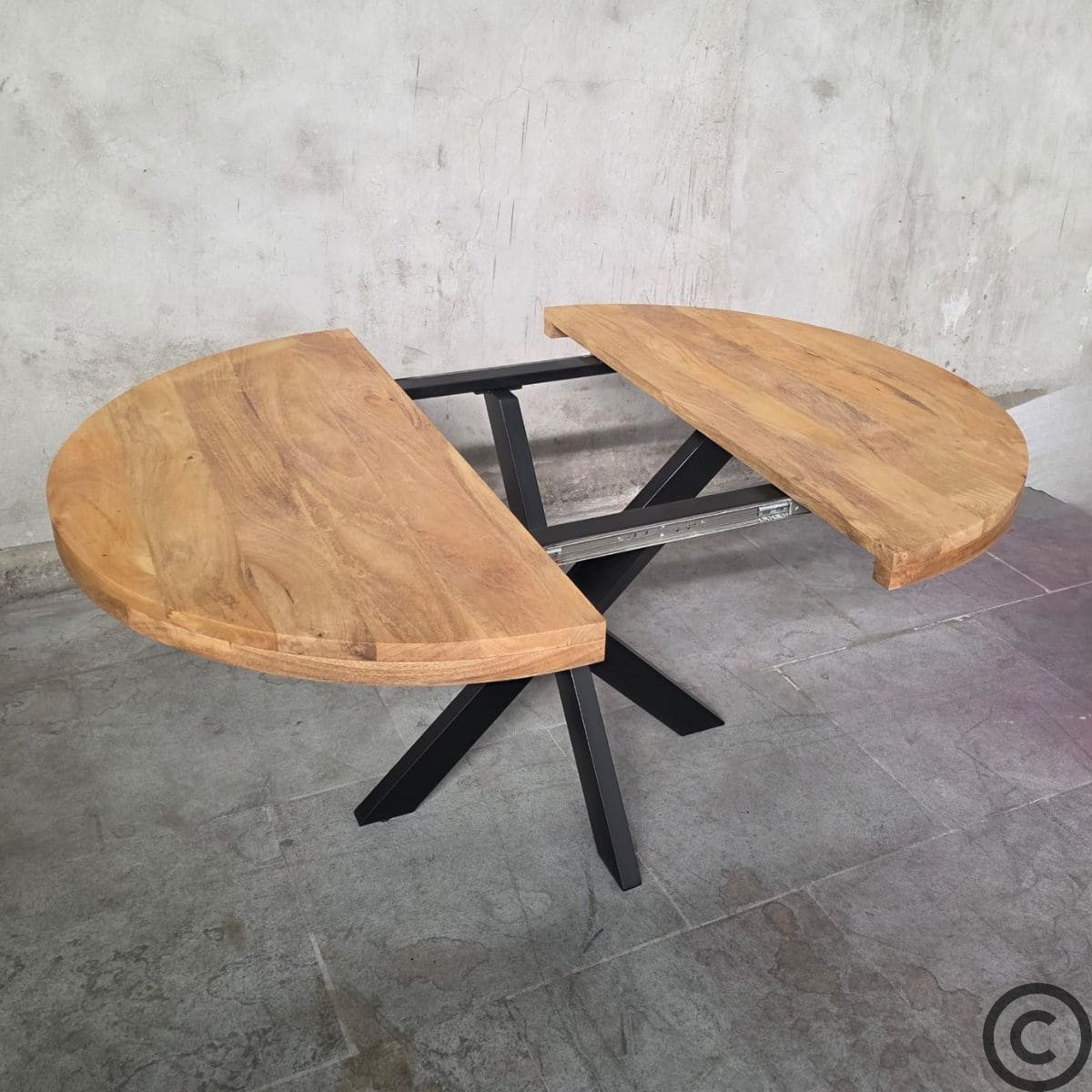 Table ronde extensible industrielle ouverte vue de biais avec pieds mikado en métal