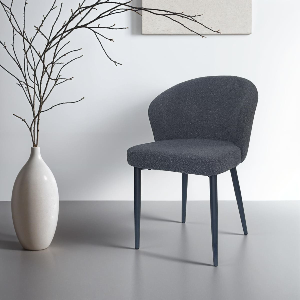 Chaise moderne en tissu bouclette gris anthracite avec dossier rond et pieds en métal noir, mise en scène dans un intérieur design minimaliste – KUKUU.