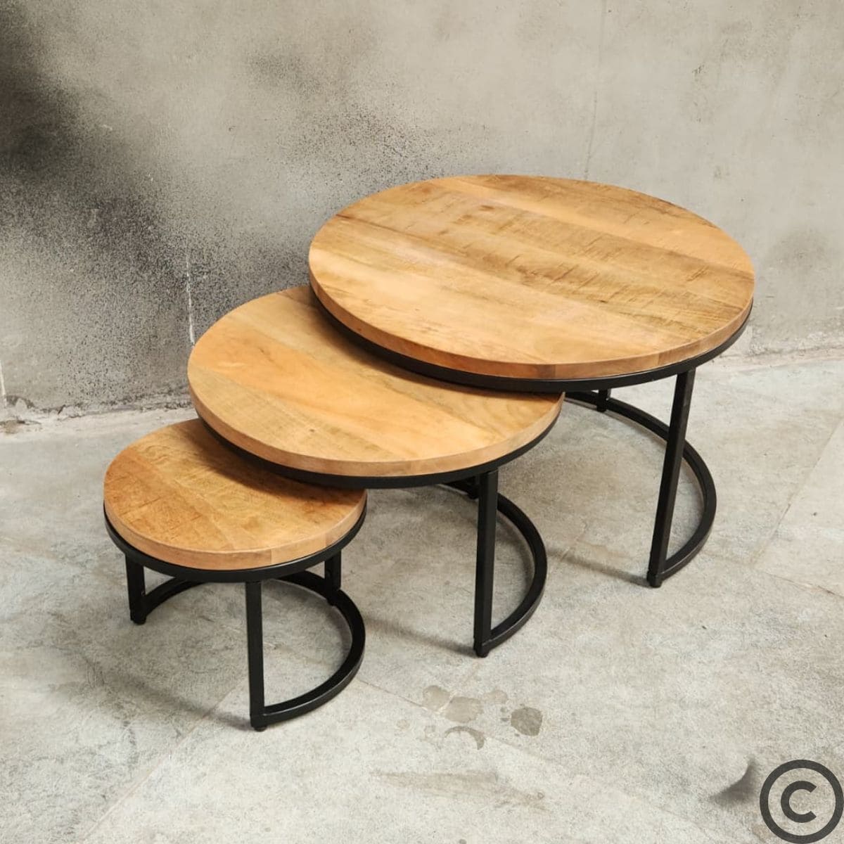 Vue d’angle de tables basses gigognes rondes en manguier et métal noir, design industriel – KUKUU