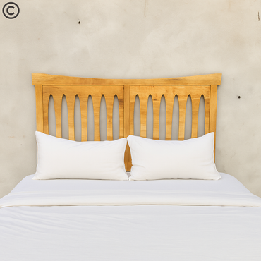 Tête de lit en manguier massif ajourée à formes ovales, installée derrière un lit double au linge blanc – style naturel et élégant Kukuu.