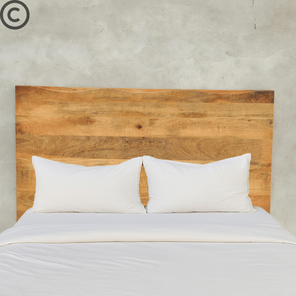 Tête de lit en manguier massif à bords naturels installée derrière un lit double avec linge blanc – design artisanal et style naturel Kukuu.