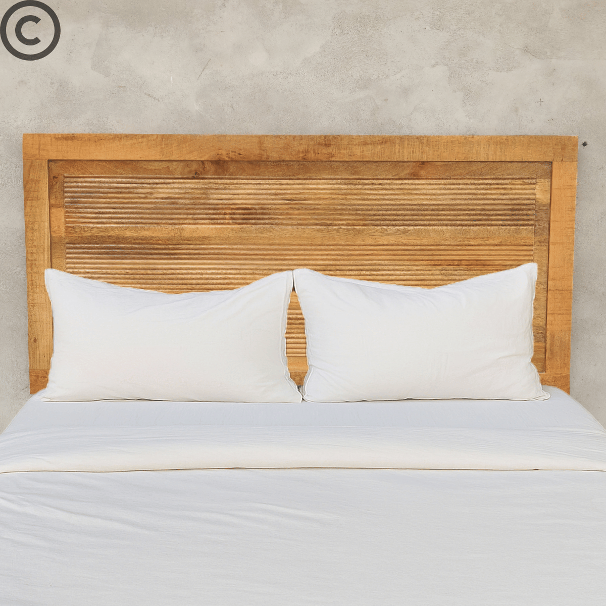 Tête de lit en manguier massif motif lignes, installée derrière un lit double avec draps blancs – design naturel Kukuu.