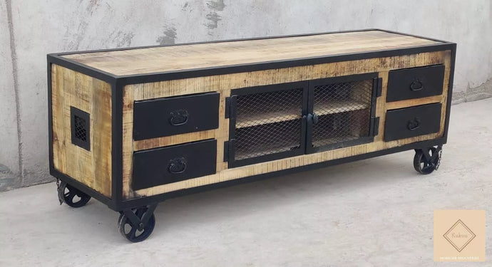 Ce meuble tv industriel à roulettes a été fabriqué à partir d'une structure en bois massif de manguier et d'éléments en métal. Il est composé de quatre tiroirs métalliques et de deux portes centrales grillagées. Dimensions: 160 (L) X 45 (l) X 55 (H) cm. Kukuu, boutique en ligne de meubles industriels.
